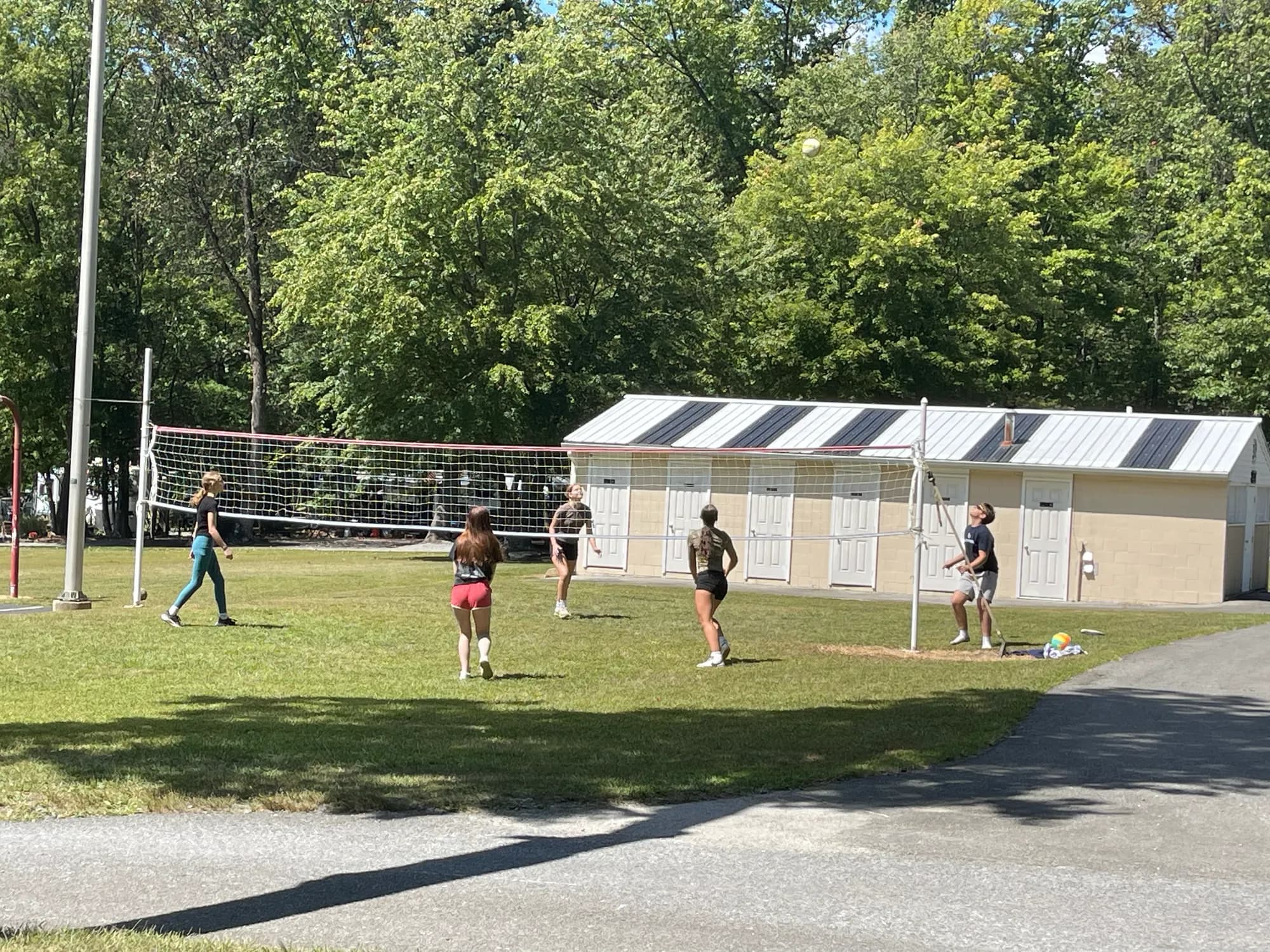 Campers playing volleyball on the grass court
