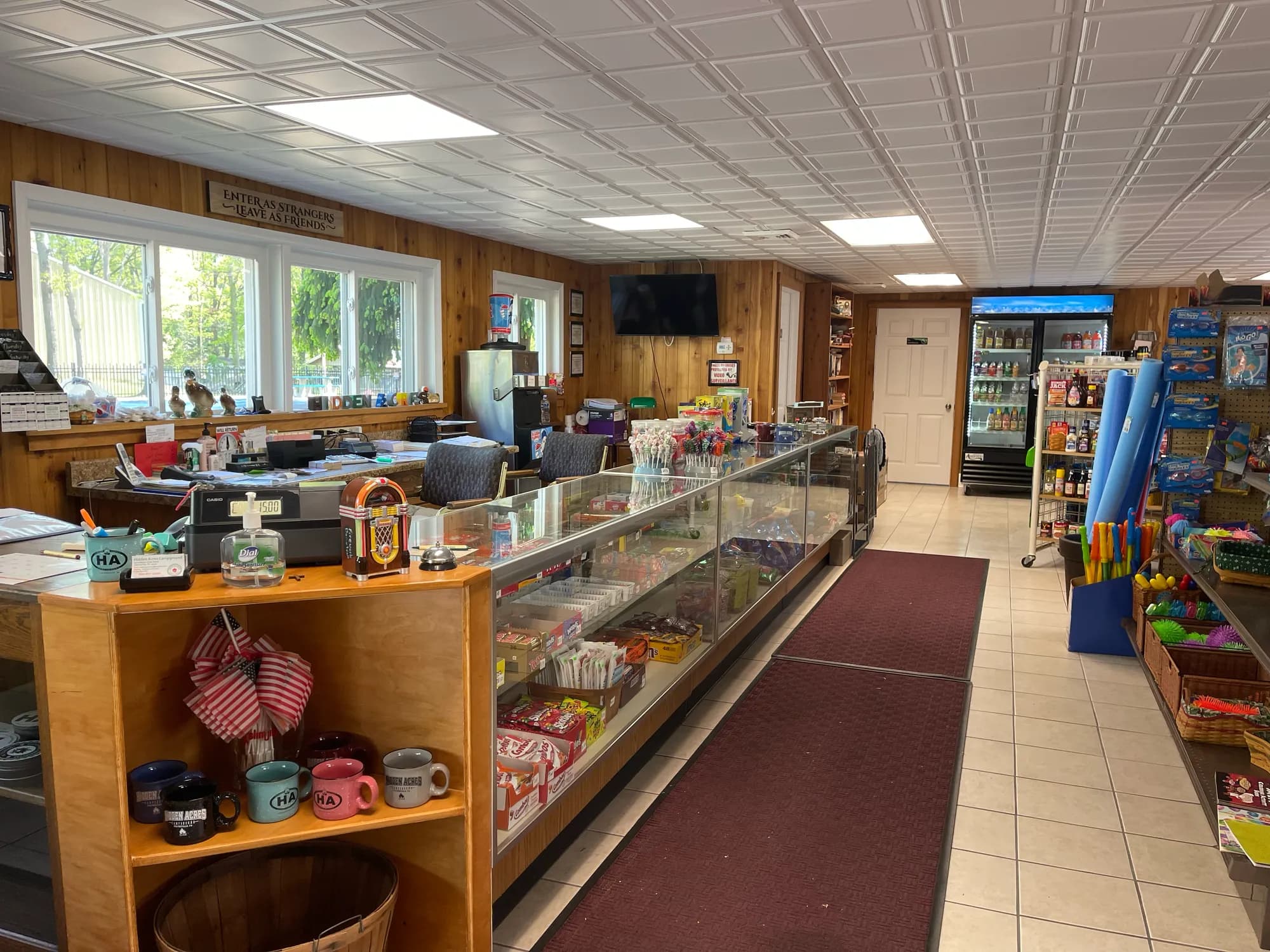 Camp store interior with checkout counter, snacks, and Hidden Acres mugs